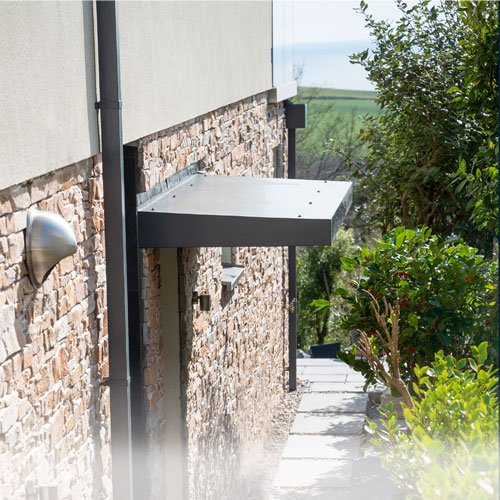 Aluminium Canopies landing page image - an contemporary Anthracite grey aluminium residential door canopy in situ on a new build property in Devon